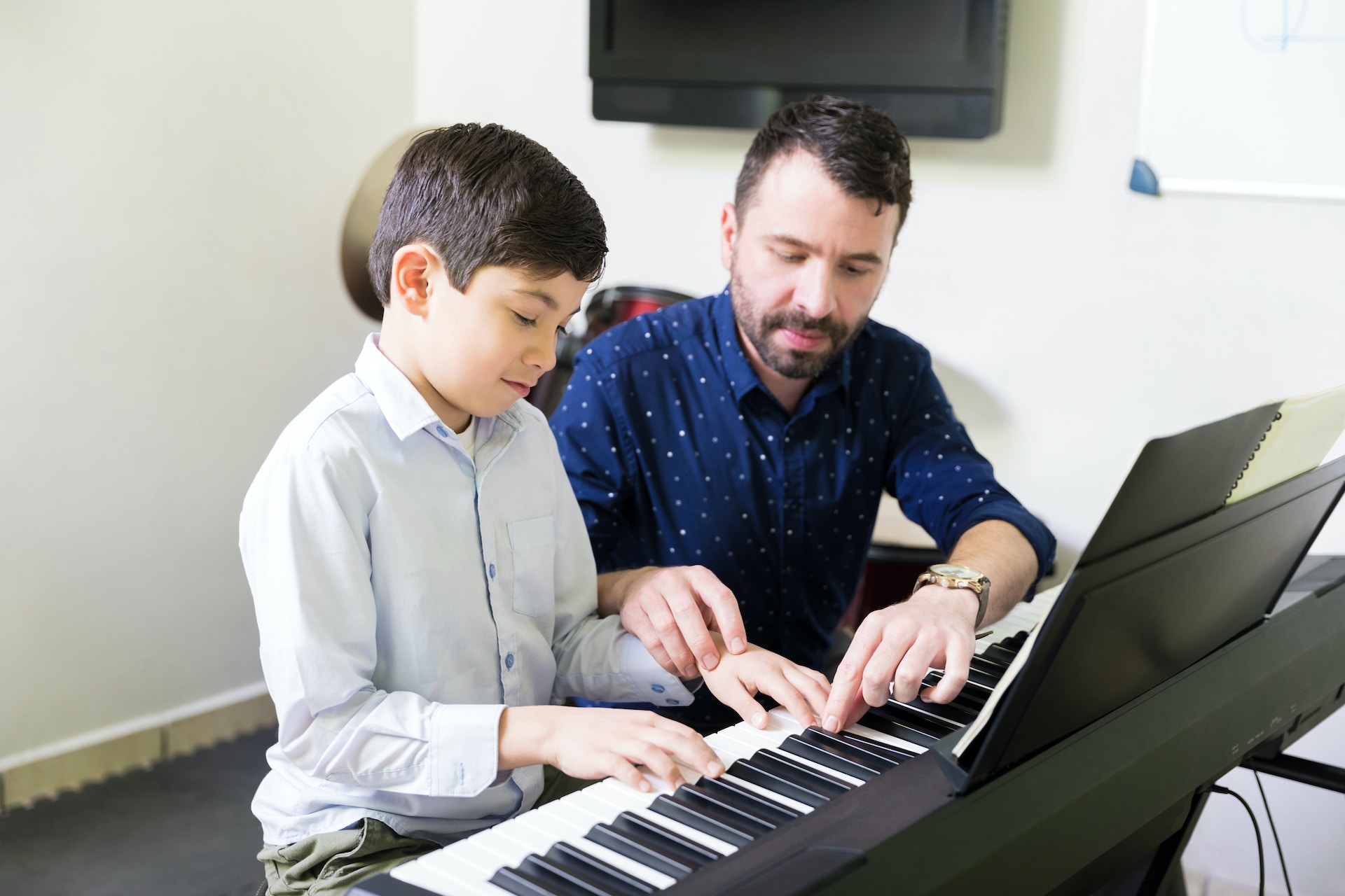 Un professeur de piano avec son élève.