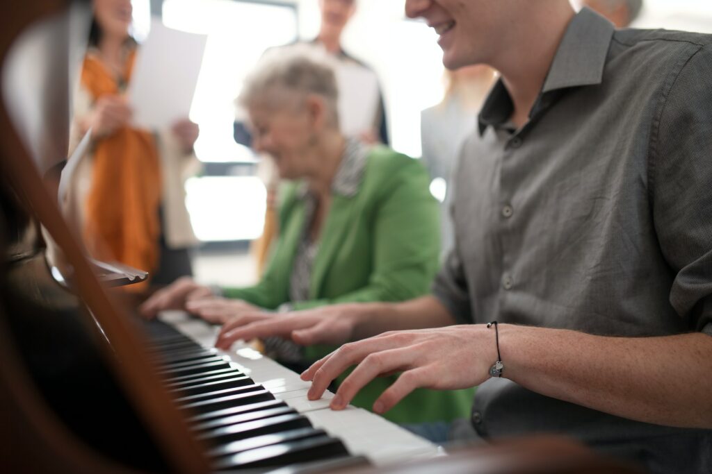 Deux personnes travaillent à quatre mains sur un piano.