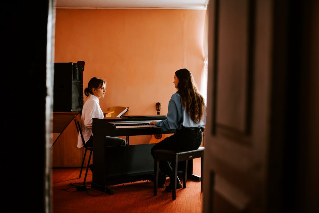 Deux personnes travaillent le piano lors d'un cours particulier.