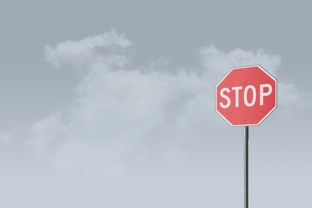 Un panneau Stop indique de s'arrêter sur la route.