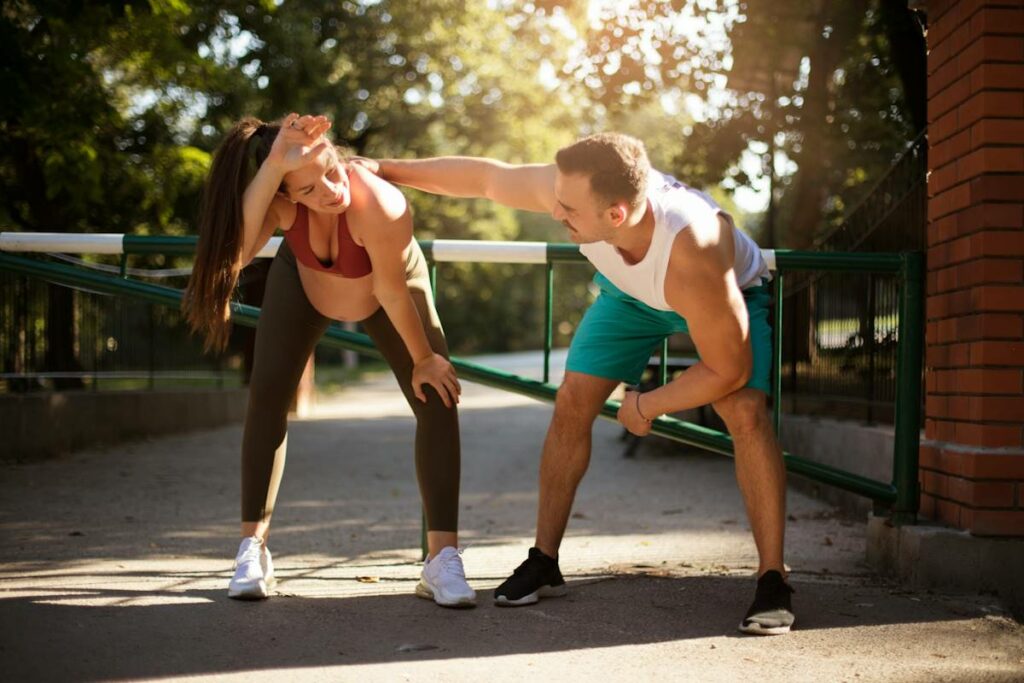 Une dame enceinte fait de l'exercice avec son professeur de sport.