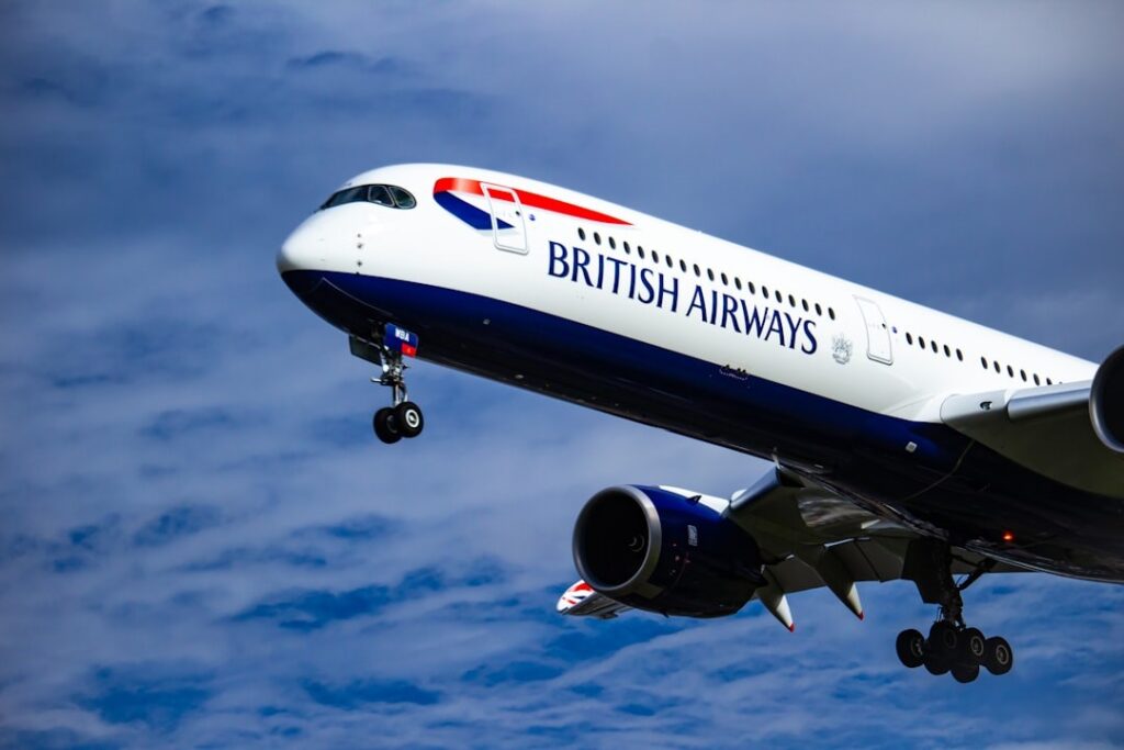 Un avion de la British Airways avec son train d'atterrissage dans les nuages.