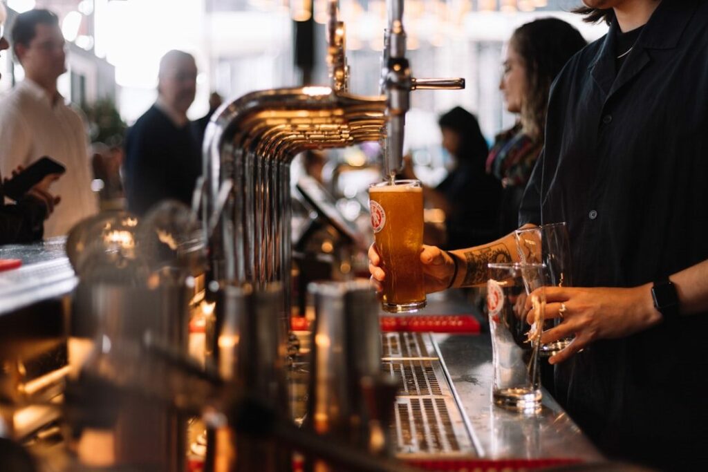 Des tireuses à bières dans un bar avec quelques clients.