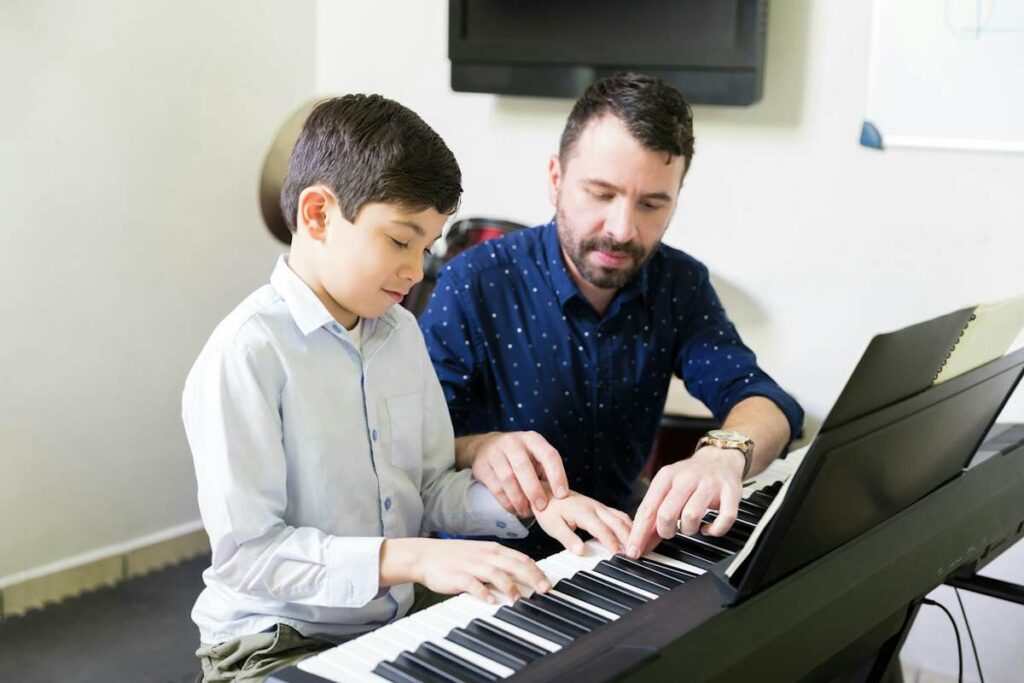 Un enseignant de piano avec un élève enfant sur le clavier d'un piano.