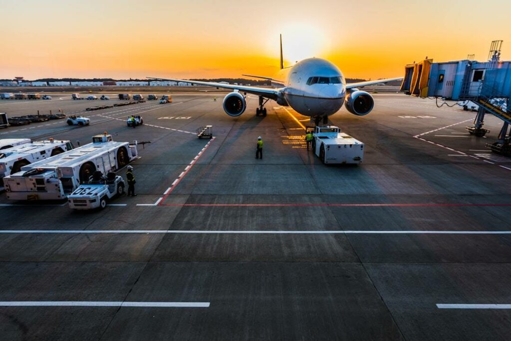 Vue d'un avion au sol, depuis la salle d'embarquement au crépuscule.