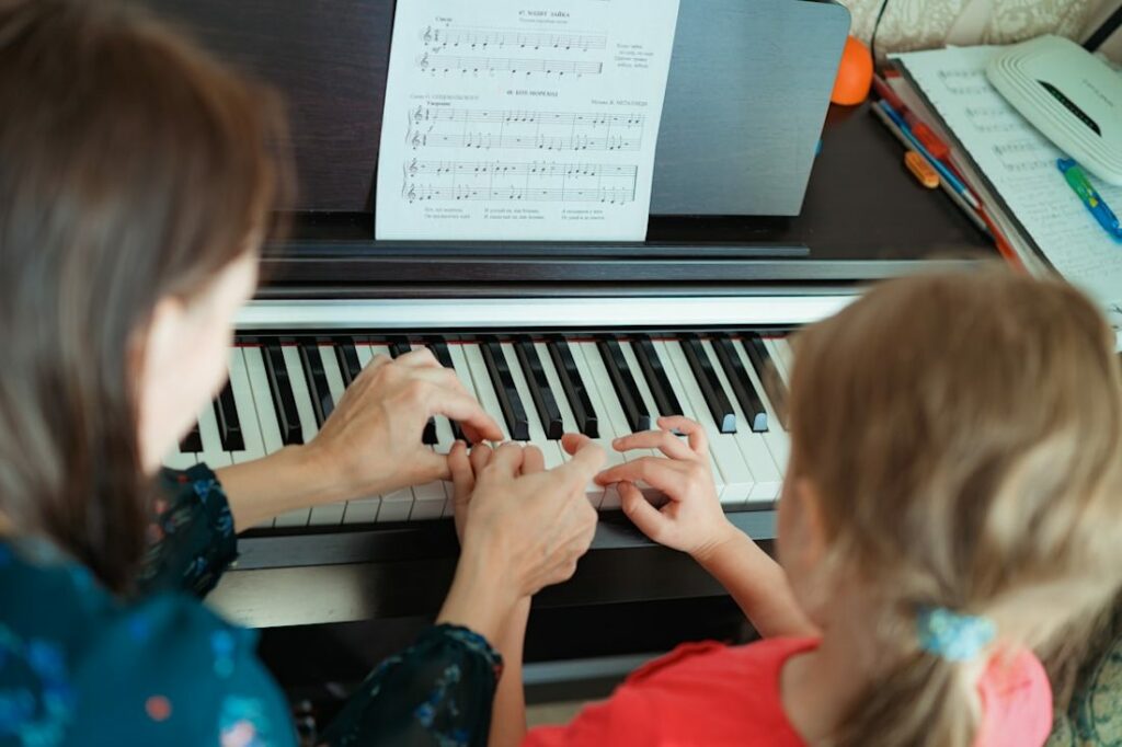 Une femme et une petite fille devant le clavier d'un piano.