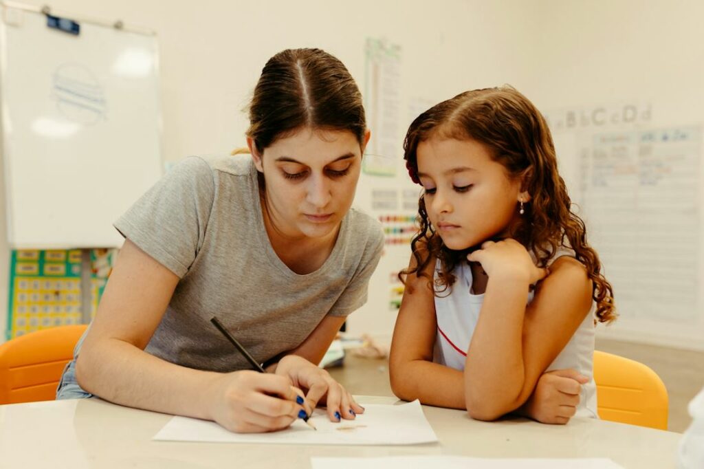 Une femme et une petite fille travaillent sur une feuille de papier.