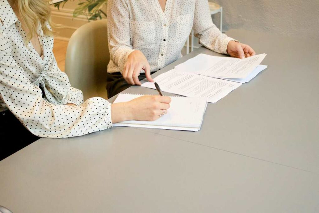 Deux personnes travaillent sur des feuilles de papier.