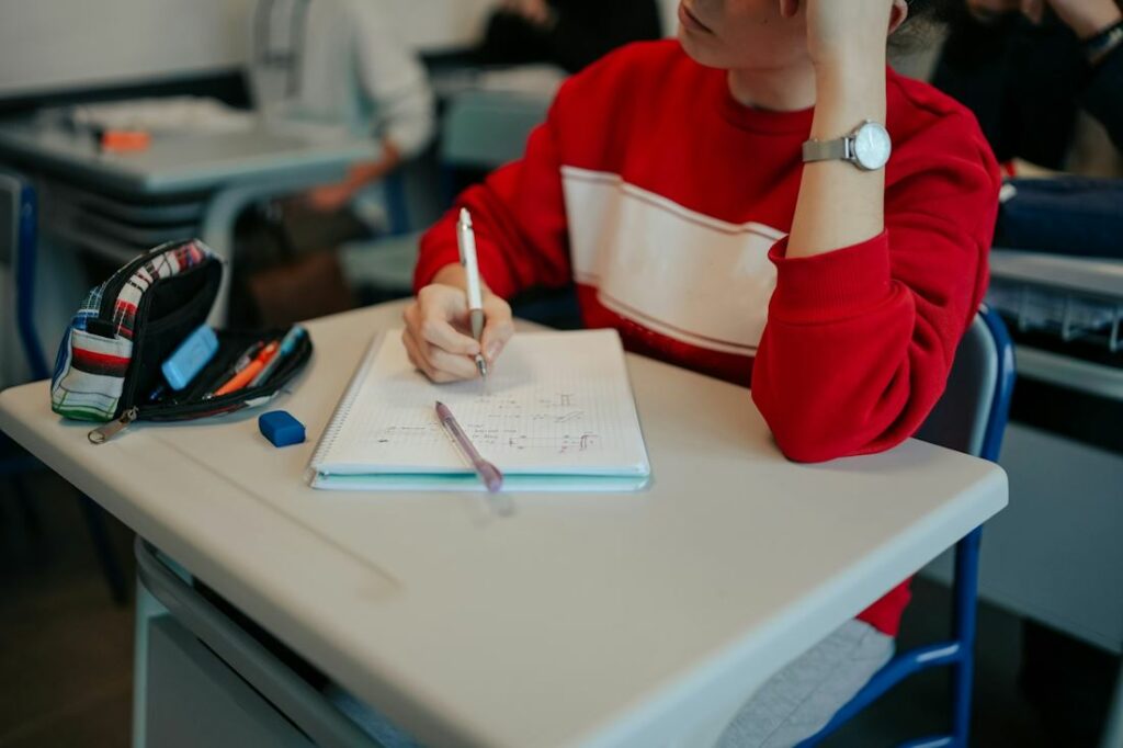 Un jeune garçon vu en train de réfléchir sur un exercice, en classe.