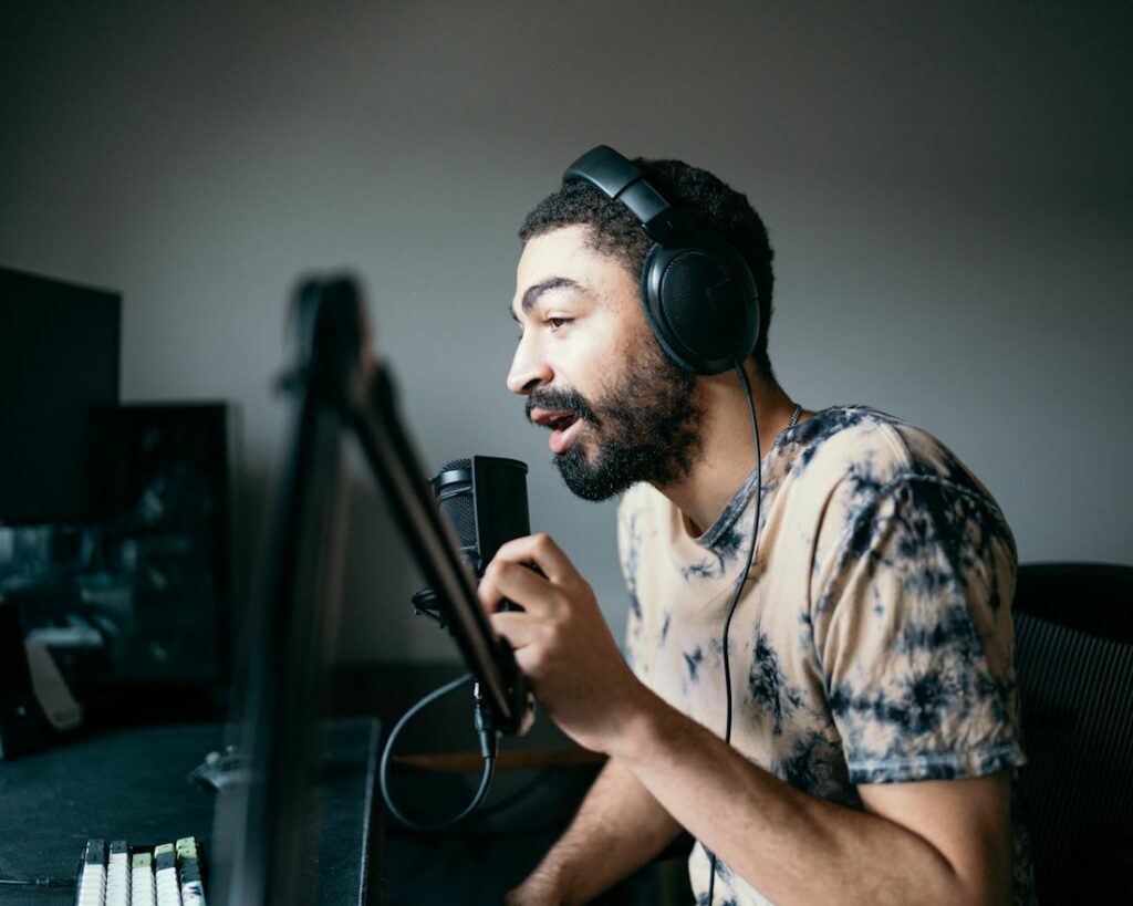 Un chanteur photographié de profil dans un studio d'enregistrement.