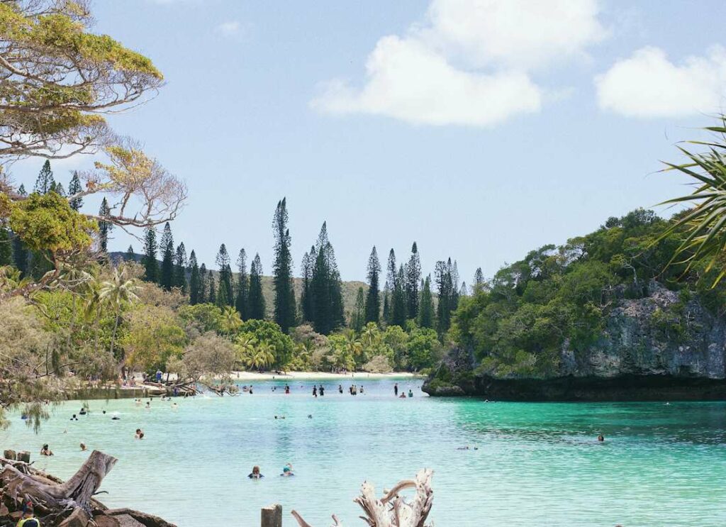 Des baigneurs dans une étendue d'eau turquoise et verte.