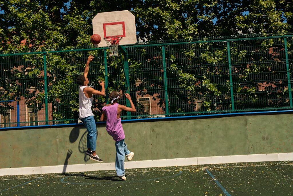 Des sportifs marquent un panier sur un terrain de basketball.