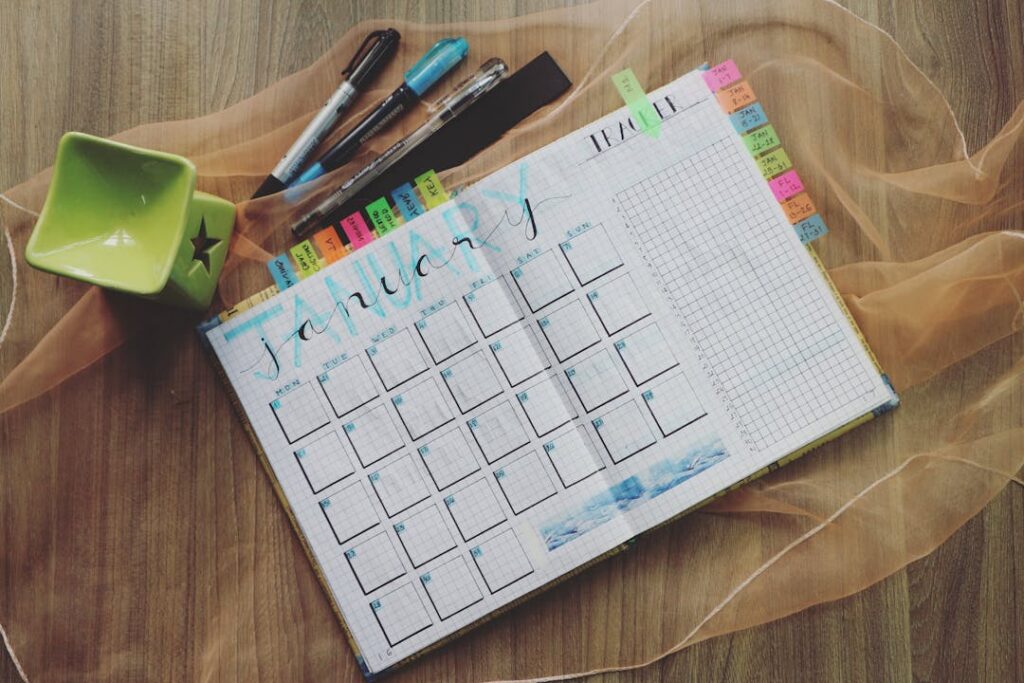 Un emploi du temps posé sur une table avec des stylos de couleur.