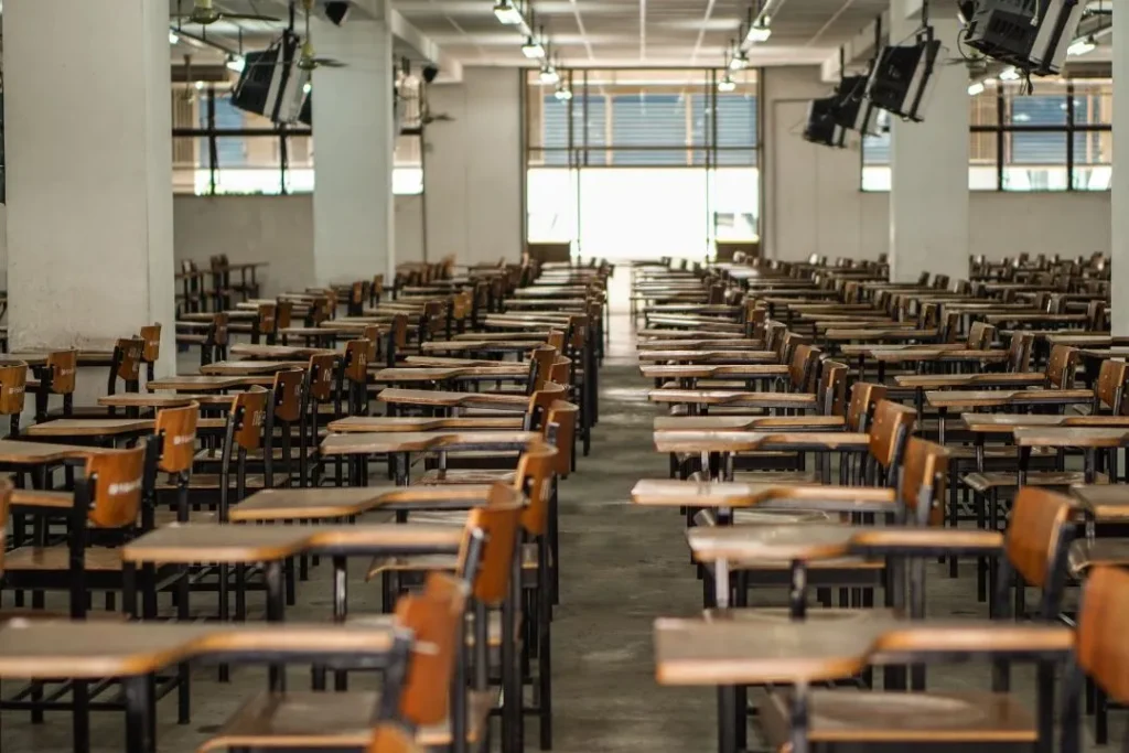 Vue d'une salle d'examen vide, avec du mobilier scolaire.