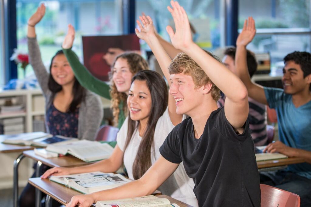 Des jeunes étudiants enthousiastes dans une salle de cours.