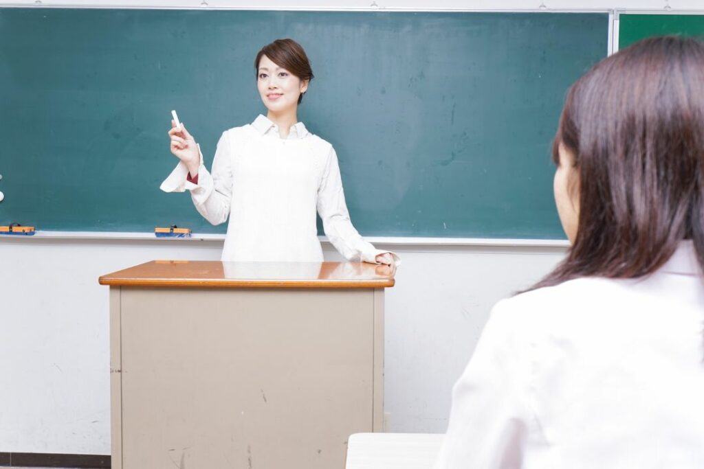 Une jeune femme donne un cours dans une salle de classe.