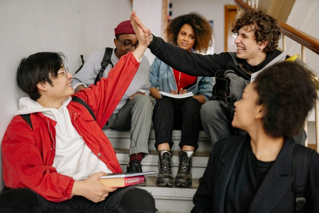 Des adolescents semblent heureux d'être ensemble, assis sur les marches d'un escalier.