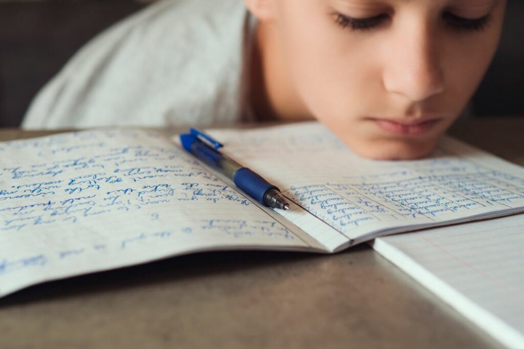 Un élève en train de regarder son cahier tristement.