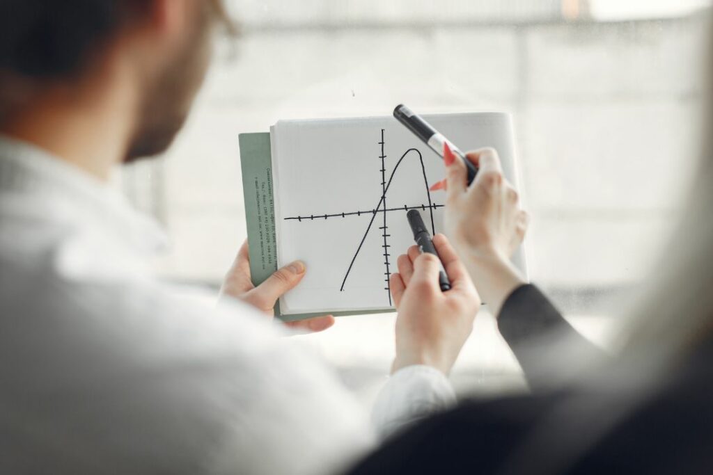 Deux personnes analysent une courbe sur un papier.