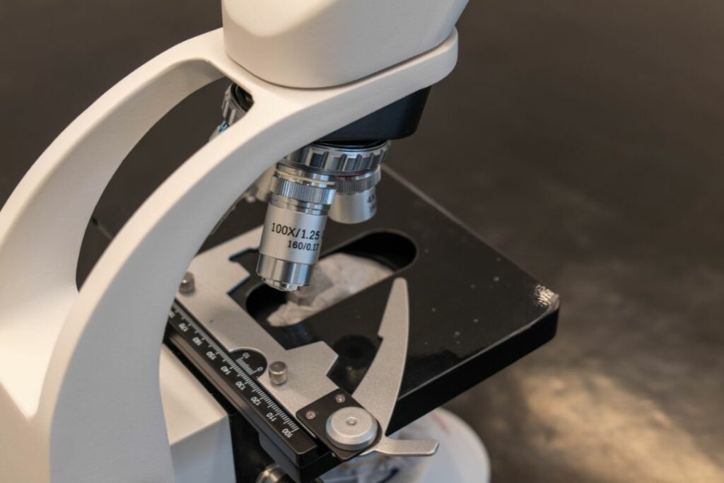 Gros plan sur un microscope optique avec objectif 100x utilisé en travaux pratiques de physique chimie.
