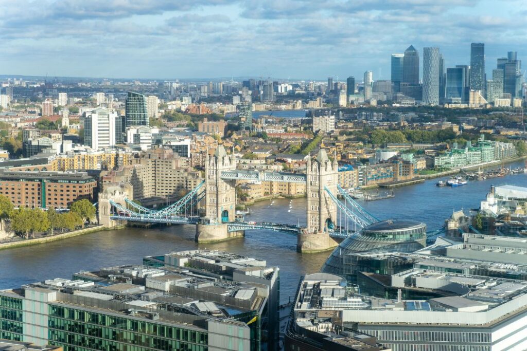 Vue aérienne panoramique de Londres avec le Tower Bridge et le quartier de Canary Wharf.