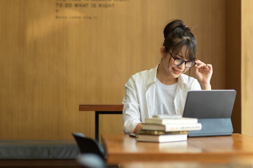 Une étudiante révise sa philosophie entourée de livres, une citation de Martin Luther King en arrière-plan."